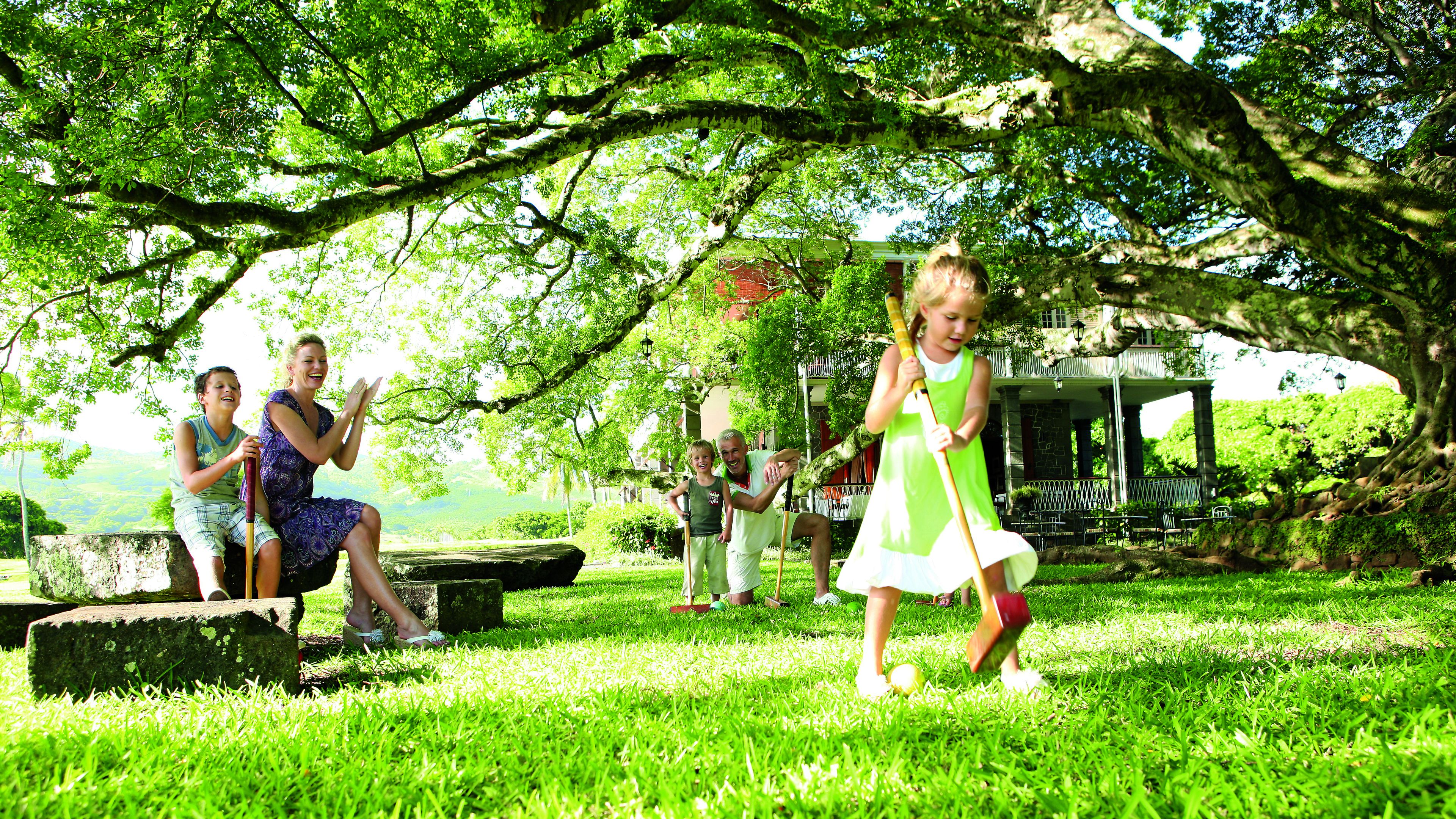 A park with a gazebo, stone benches, and lush greenery.