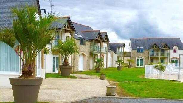 A row of two-story houses with a paved driveway and a grassy lawn. - Appart'Hôtel Mont Saint Michel Résidence Fleurdumont (Beauvoir)