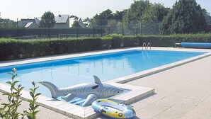 A swimming pool with a shark float and a ring float.