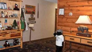 A room with a wooden wall, a desk with a lamp, and a shelf with various items. - Boarders Inn & Suites by Cobblestone Hotels – Waukon (Waukon)