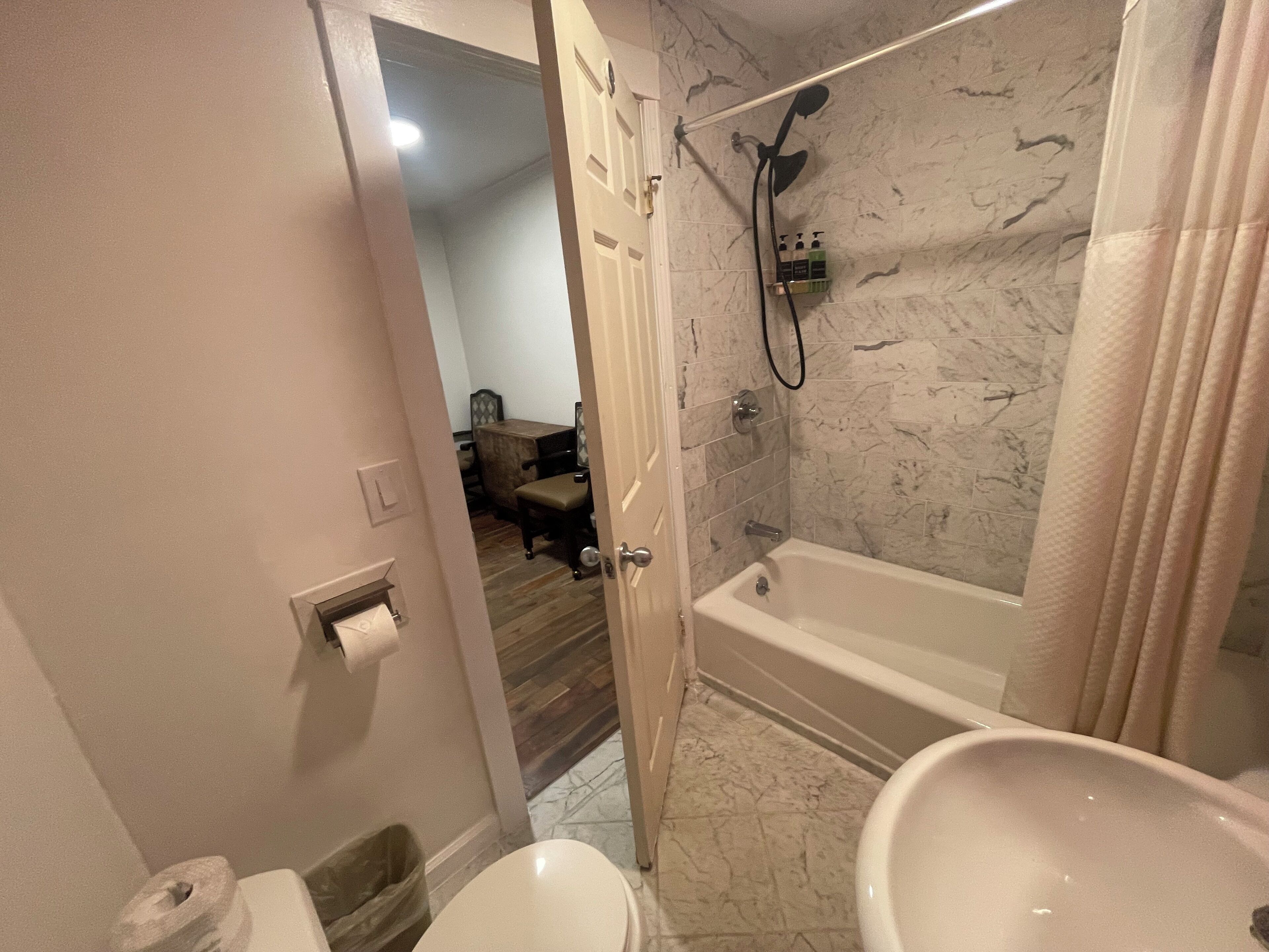 Een badkamer met een bad, een douche en een toilet.