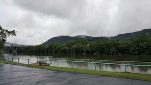 A river with a bridge in the background, surrounded by lush greenery and hills. - Budget Host Inn Charleston (Charleston)