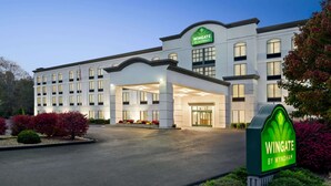 Un hotel grande y moderno con una entrada destacada y un letrero que dice "Wingate by Wyndham".