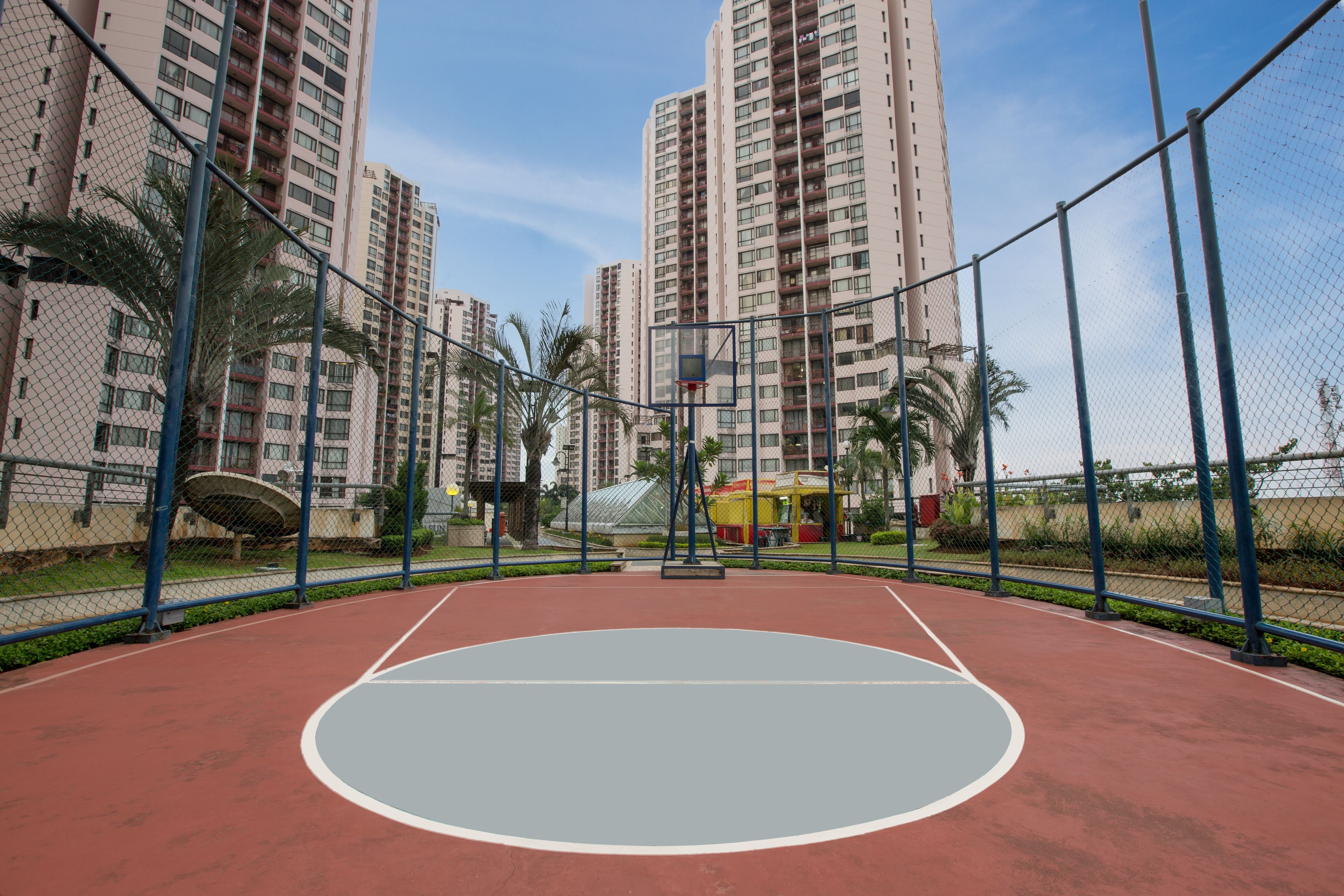 Un campo da basket all'aperto circondato da palazzi residenziali.