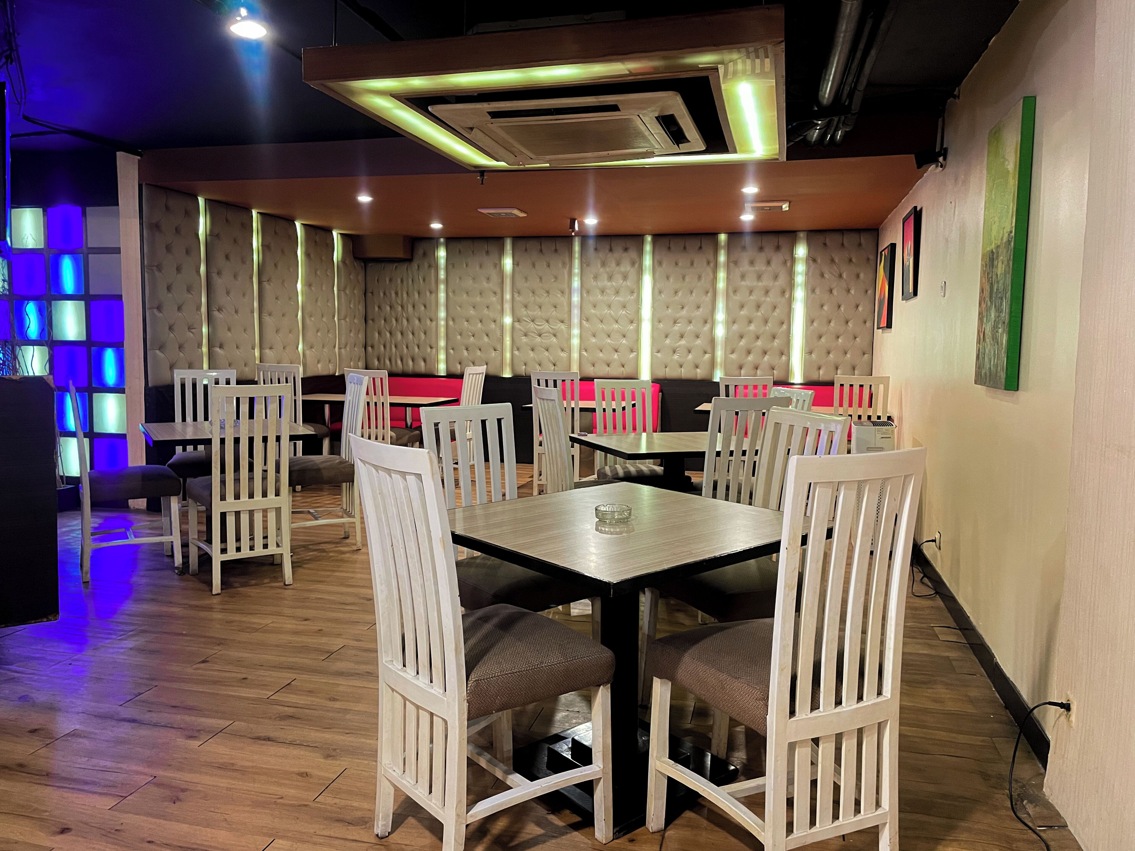 L'intérieur d'un restaurant avec des banquettes, des tables et un plancher en bois.