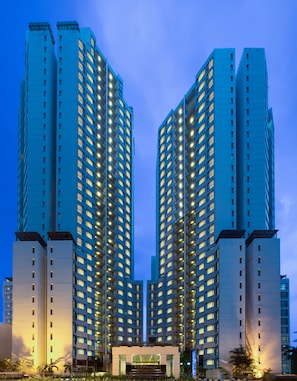 A high-rise hotel with a symmetrical facade, multiple floors, and illuminated windows.