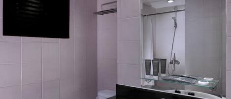 Un baño moderno con un lavamanos blanco, encimera negra y un espejo grande.