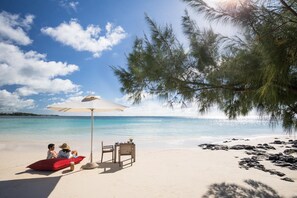 On the beach, white sand, sun loungers, beach umbrellas