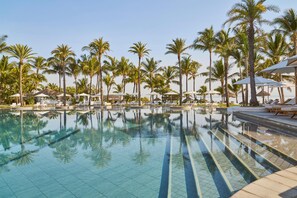 Een buitenzwembad, parasols voor strand/zwembad