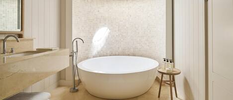 Ein modernes Badezimmer mit einer freistehenden Badewanne, einem Waschtisch und einem Spiegel.