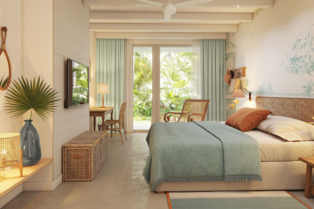Een slaapkamer met een bed, een bureau, een stoel, een televisietoestel en uitzicht op groen buiten het raam.