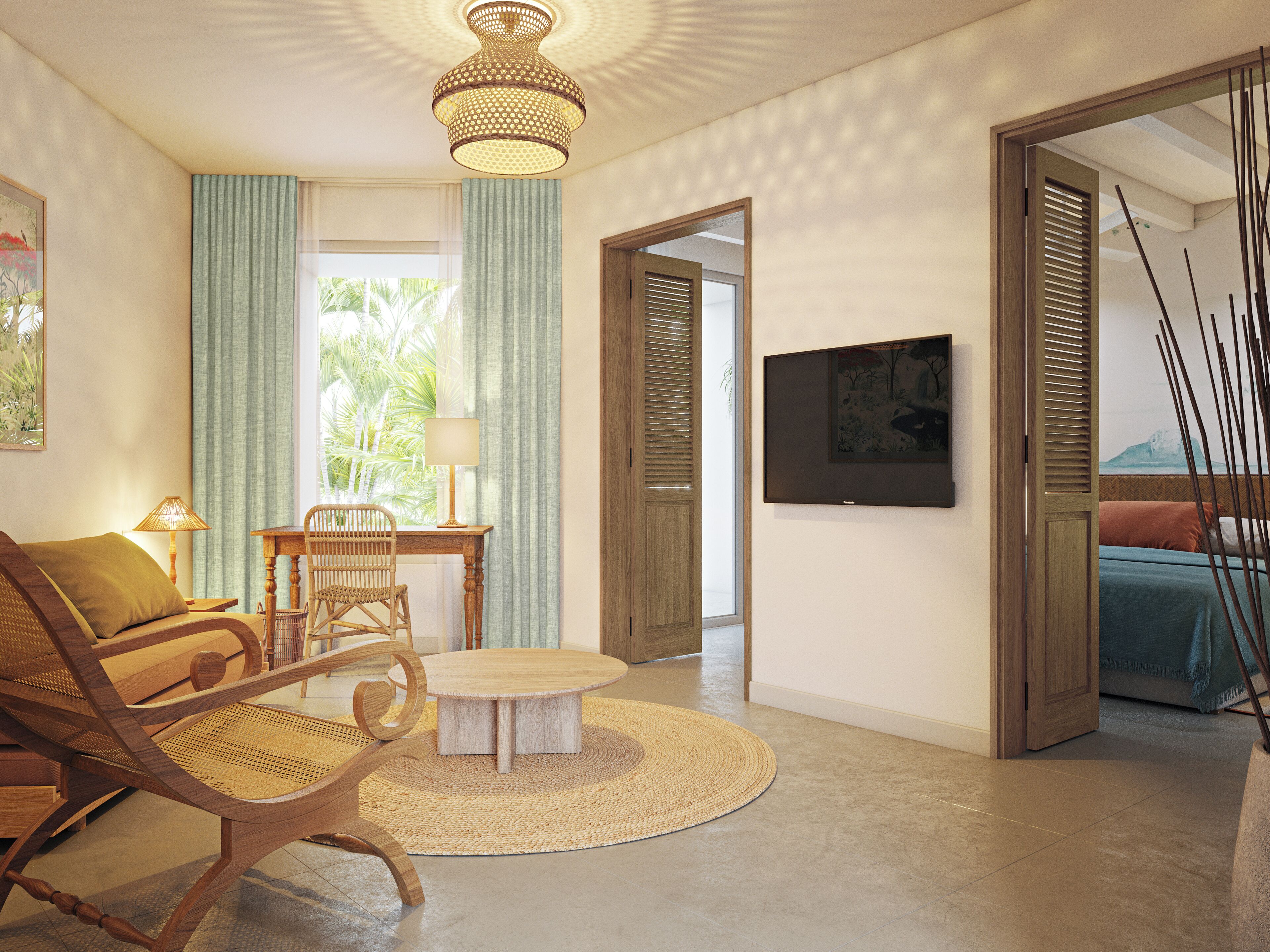 Una sala de estar bien iluminada con una mesa redonda de madera, una silla de mimbre y una mesa de comedor con sillas. Hay un televisor montado en la pared y una puerta que da a otra habitación.