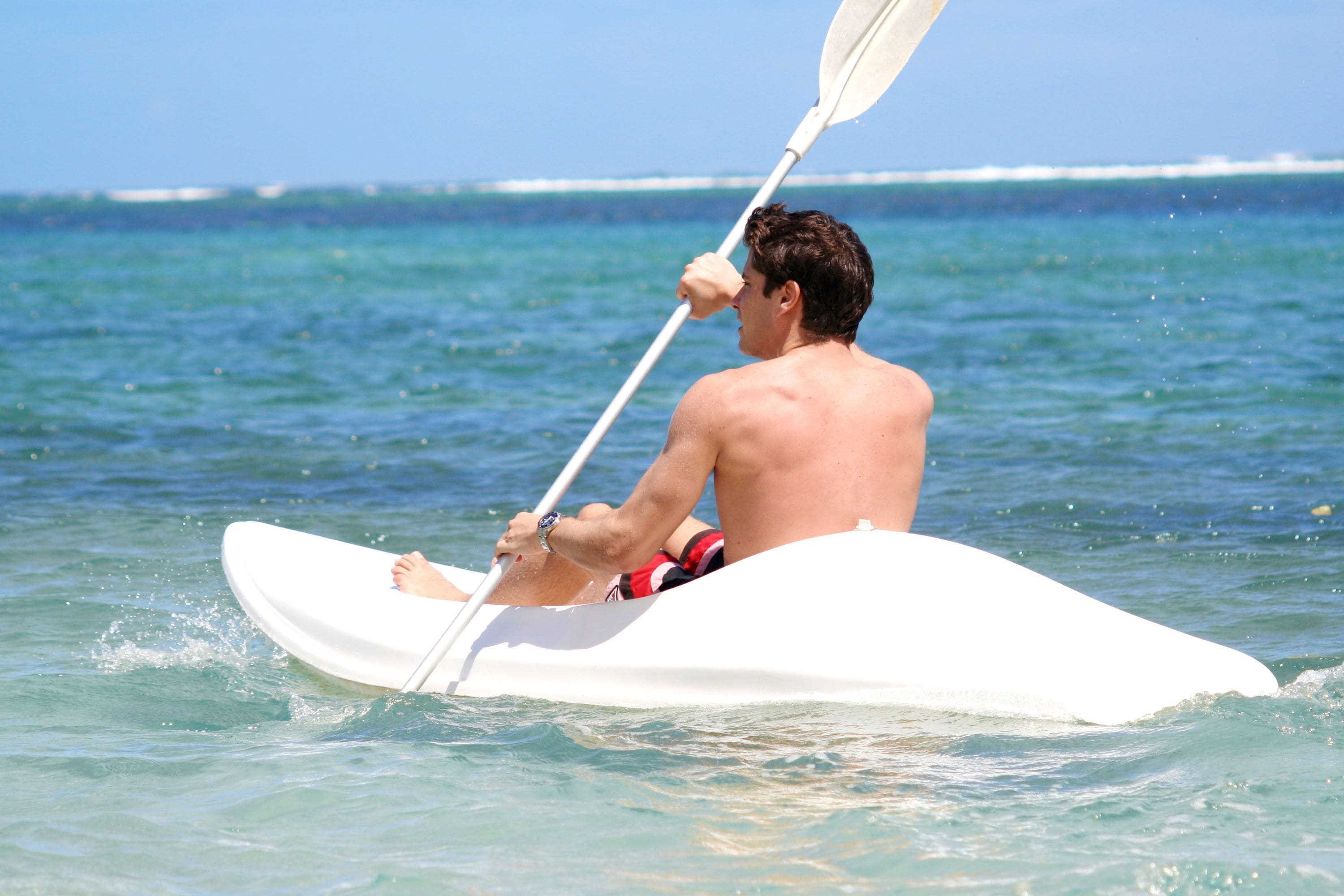 A person kayaking on a calm sea.