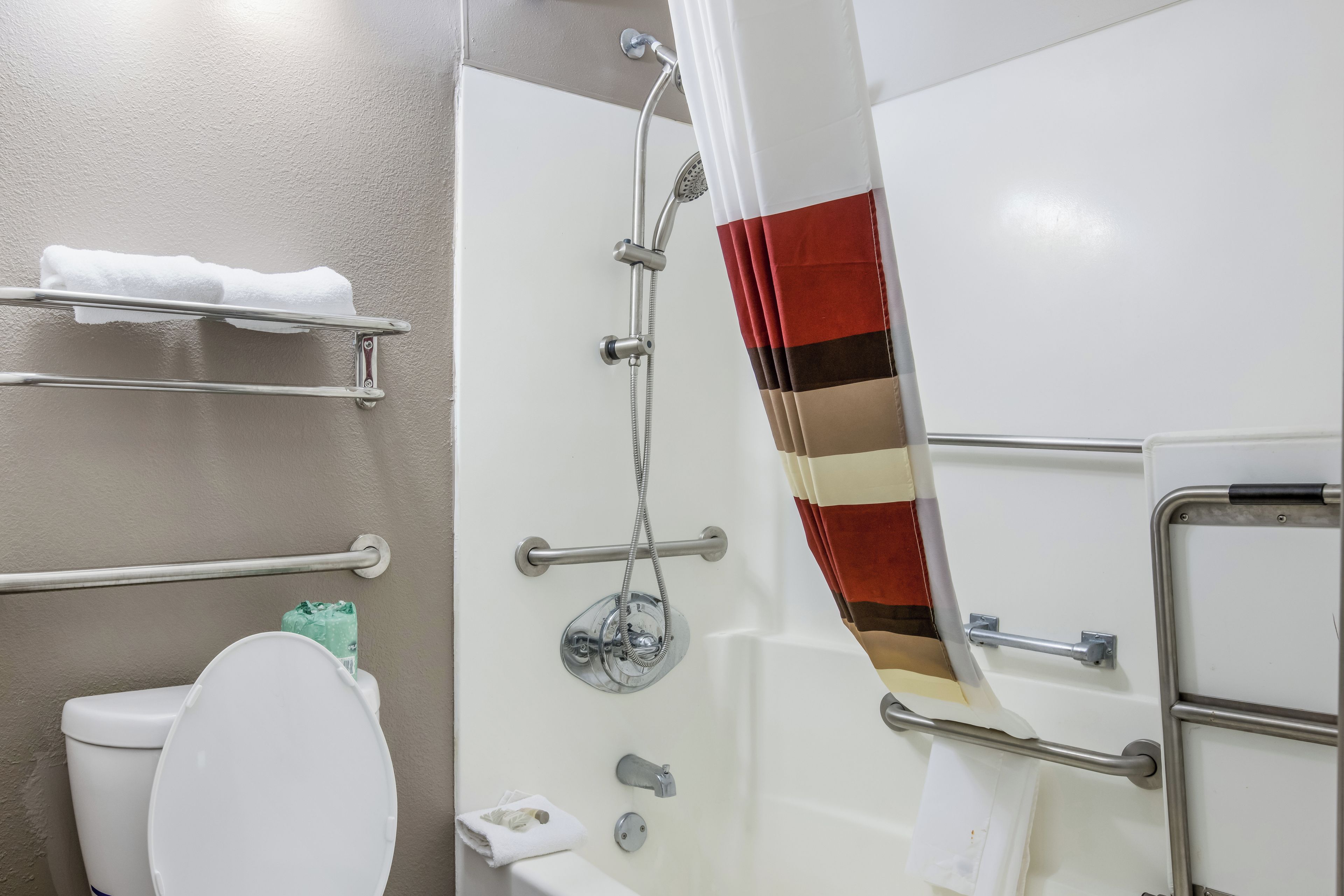 Ein Badezimmer mit Dusche, Toilette und Handtuchhalter.