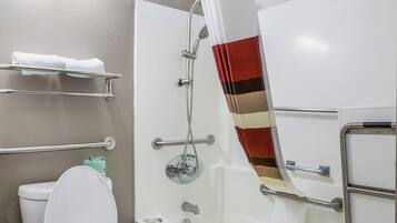 Ein Badezimmer mit Dusche, Toilette und Handtuchhalter.