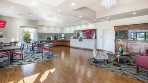 Un hall d’hôtel spacieux comprenant un comptoir d’accueil, un espace salon et une vue sur l’extérieur.