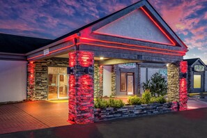 Un restaurante con fachada de piedra e iluminación roja, que muestra un letrero de 'Coz's Mexican' y un letrero con una 'Bandera'.
