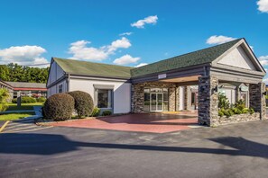 A building with a covered entrance, stone pillars, and a sign indicating a 9-car parking area. - Red Roof Inn Savannah - Richmond Hill/ I-95 (Richmond Hill)