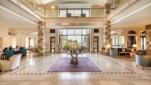 A spacious lobby with a high ceiling, a central round table, and a view of the outdoors.