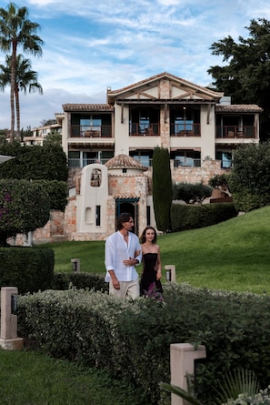 A large, multi-story building with a stone facade and a central courtyard. - Columbia Beach Resort (Pissouri)