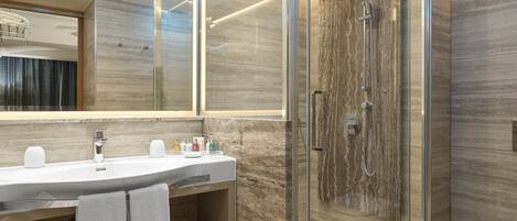 A modern bathroom with a glass-enclosed shower, a vanity with a sink, and a toilet.