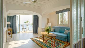 A spacious living room with a blue sofa, a wooden coffee table, and a patterned rug.