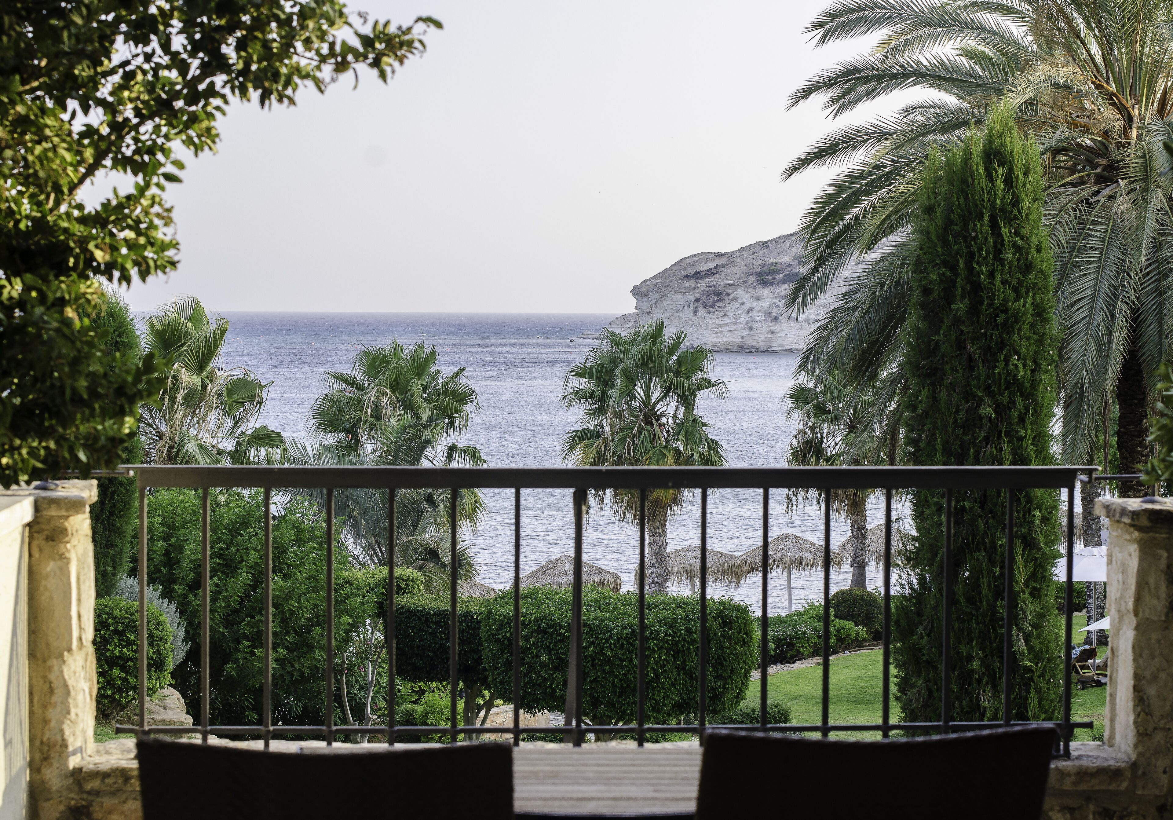 A balcony with a view of the sea and a cliff.