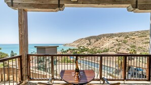A balcony with a table and chairs, overlooking a pool and a mountainous landscape. - Columbia Beach Resort (Pissouri)