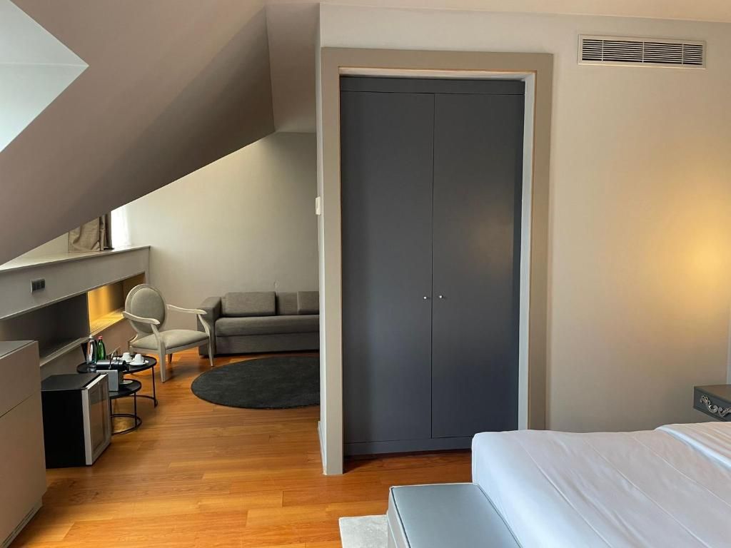 A modern bedroom with a bed, a desk, a chair, and a wardrobe.