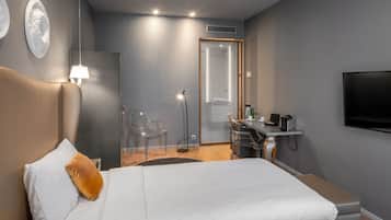 Une chambre d’hôtel moderne, dotée d’un grand lit, d’un bureau et d’une télévision.