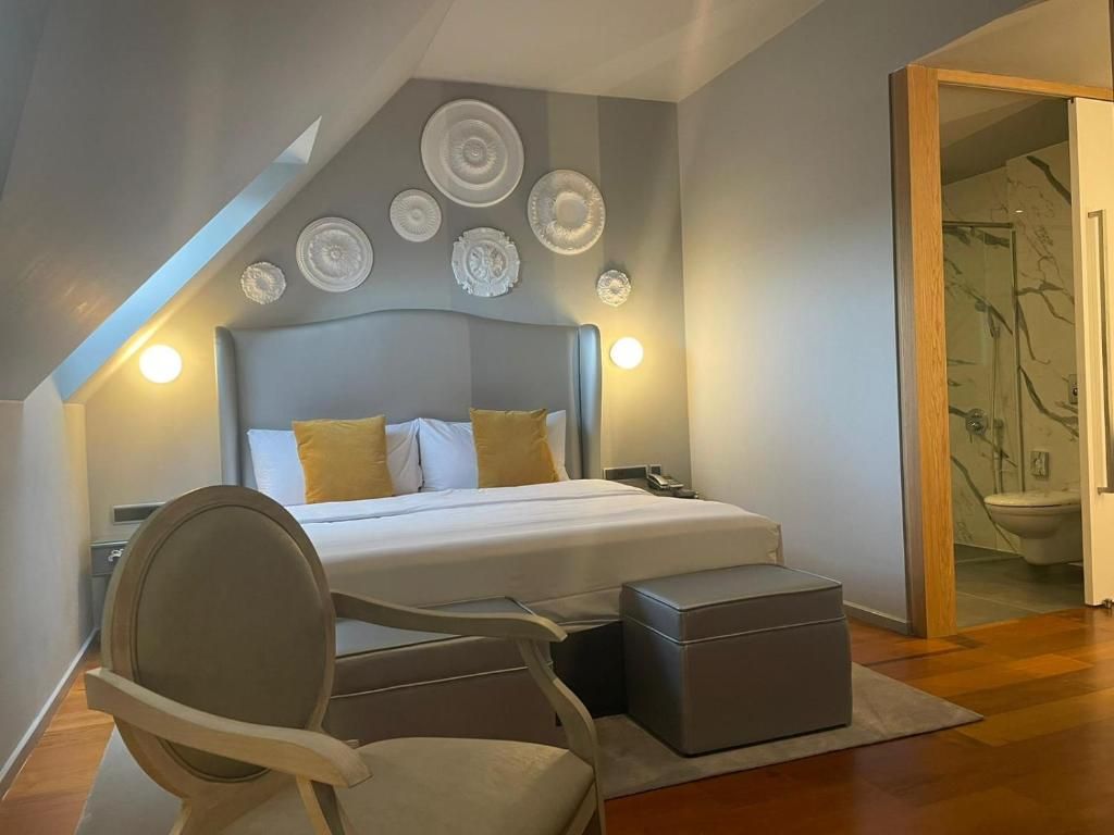 A bedroom with a bed, bedside tables, a chair, and a small table.
