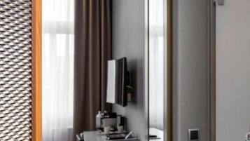 Une salle de bain moderne avec un grand miroir, un lavabo et un téléviseur fixé au mur.