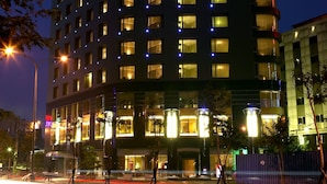 A multi-story hotel with illuminated signage and windows. - Grand Forward Hotel (New Taipei City)