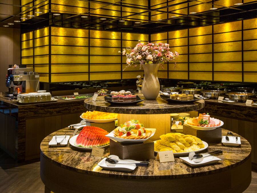 A buffet with various food items and a coffee machine.