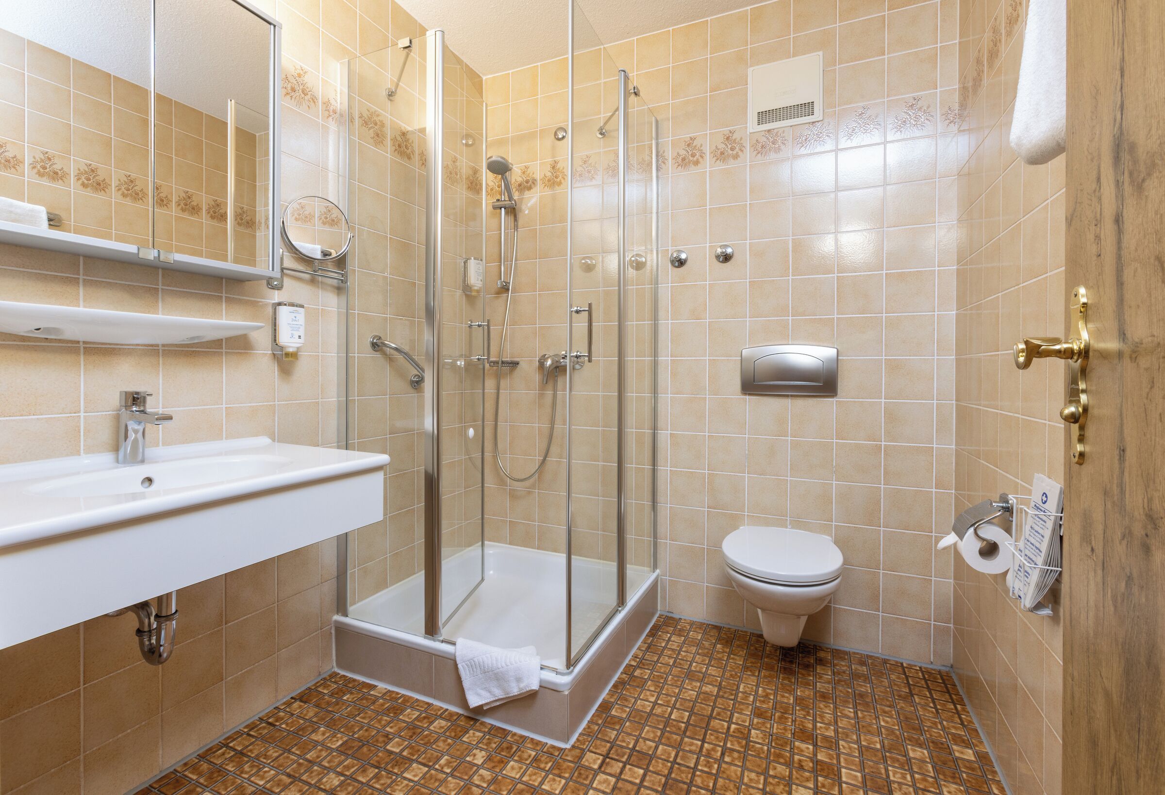 Un baño con ducha, inodoro, lavabo y toallero.
