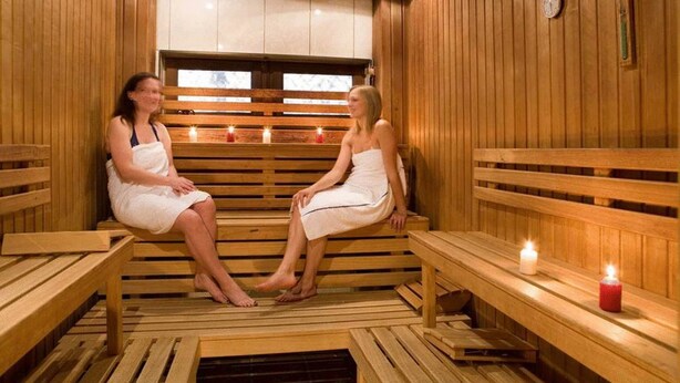 A wooden sauna with benches and candles. - Sporthotel Wilder Kaiser (Oberaudorf)