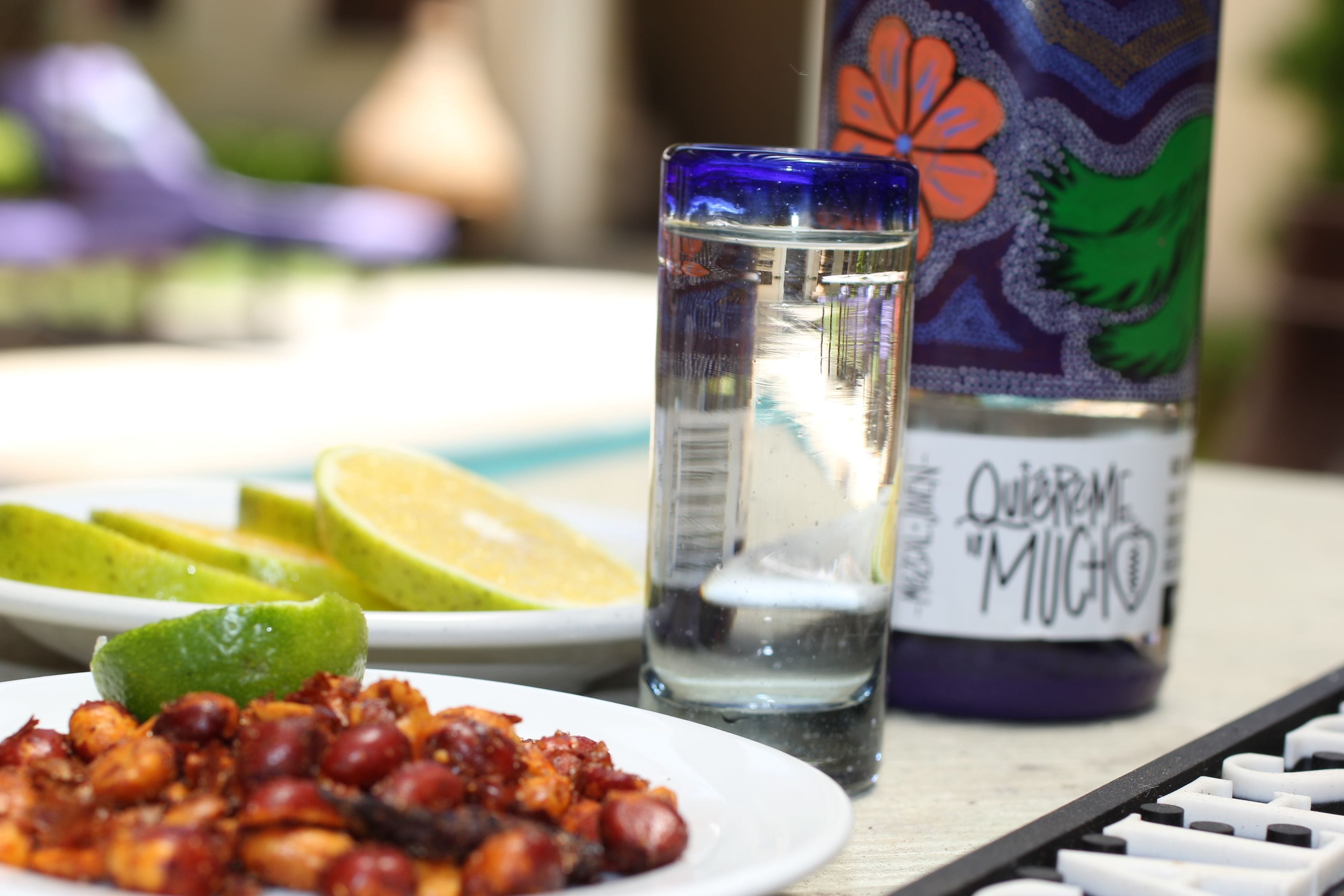 A plate of food, a glass of water, and a bottle with a floral design.