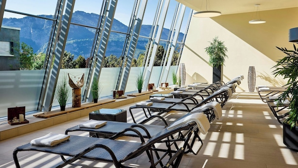A sunlit indoor seating area with a view of mountains through large windows. - Four Points By Sheraton Panoramahaus Dornbirn (Dornbirn)