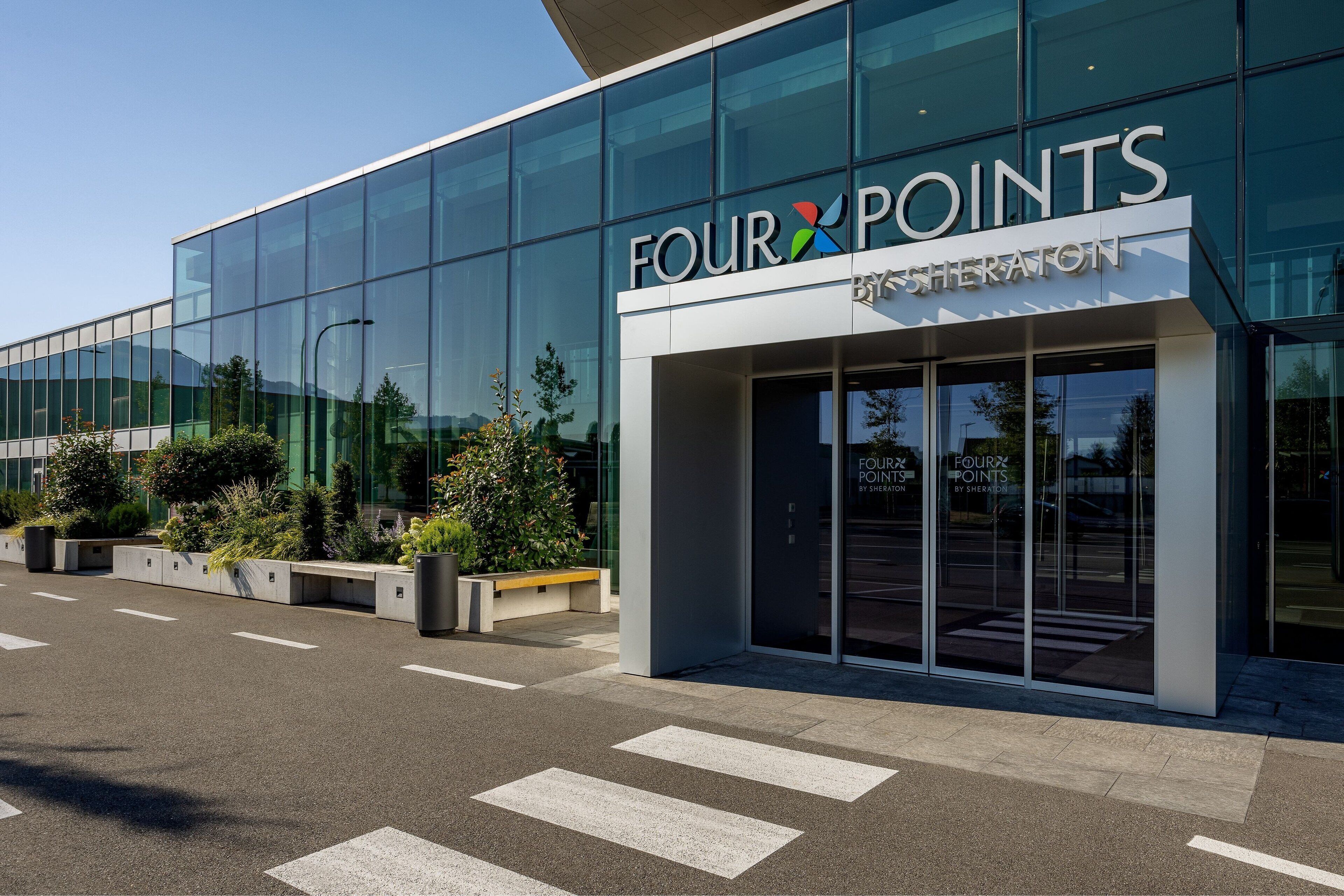 A modern building with a glass facade and the name "FOUR POINTS" prominently displayed.