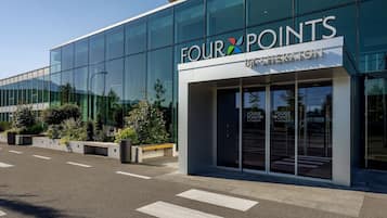 Ein modernes Gebäude mit Glasfassade, auf der das Wort "FOUR POINTS" gut sichtbar angebracht ist.