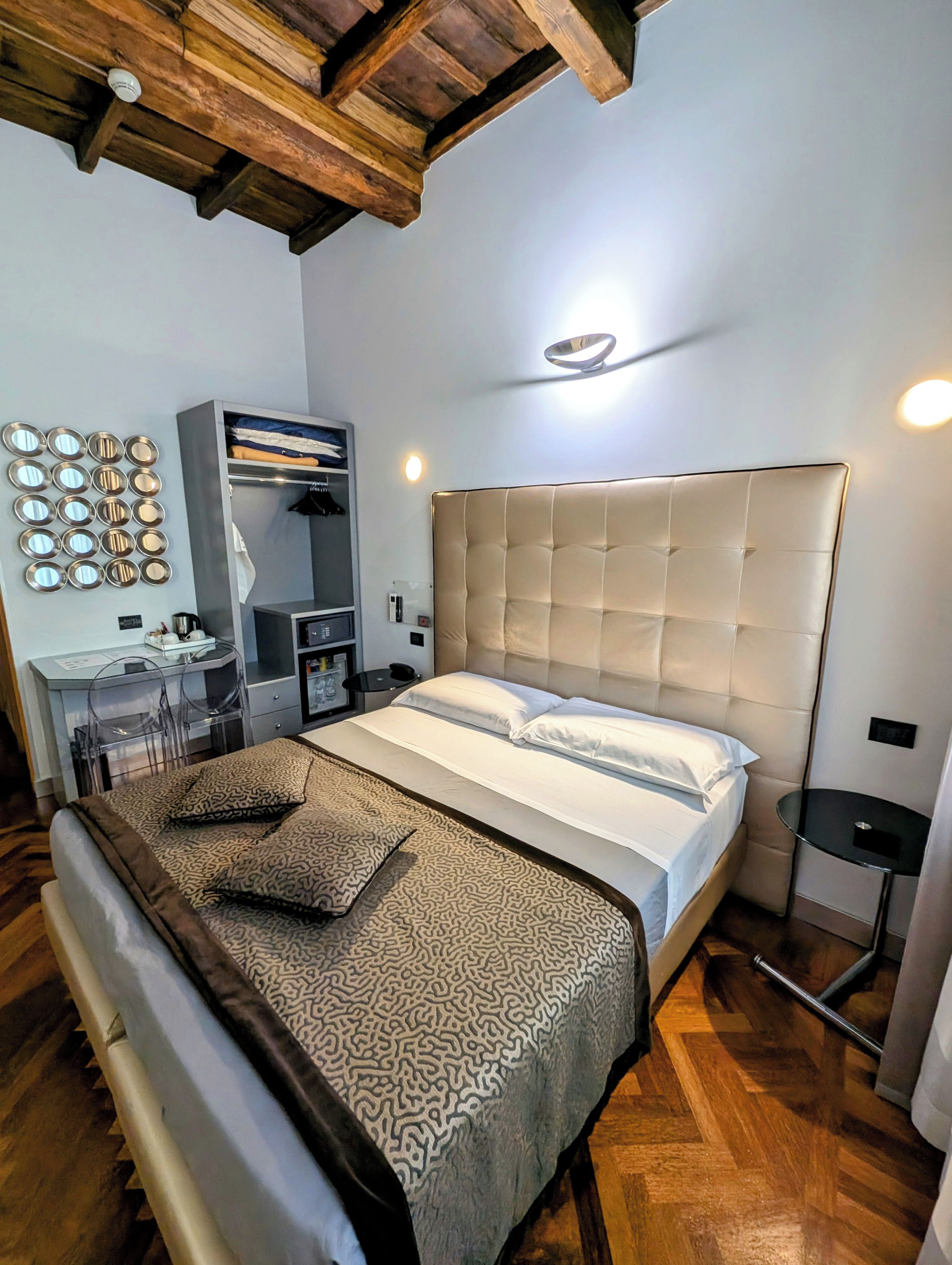 A bedroom with a bed, a desk, and a wardrobe.