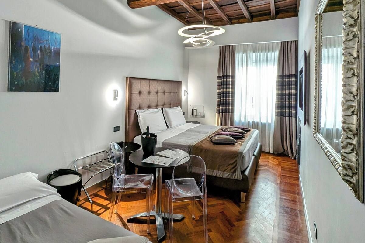 A hotel room with a wooden ceiling, a bed, a desk, and a chair.