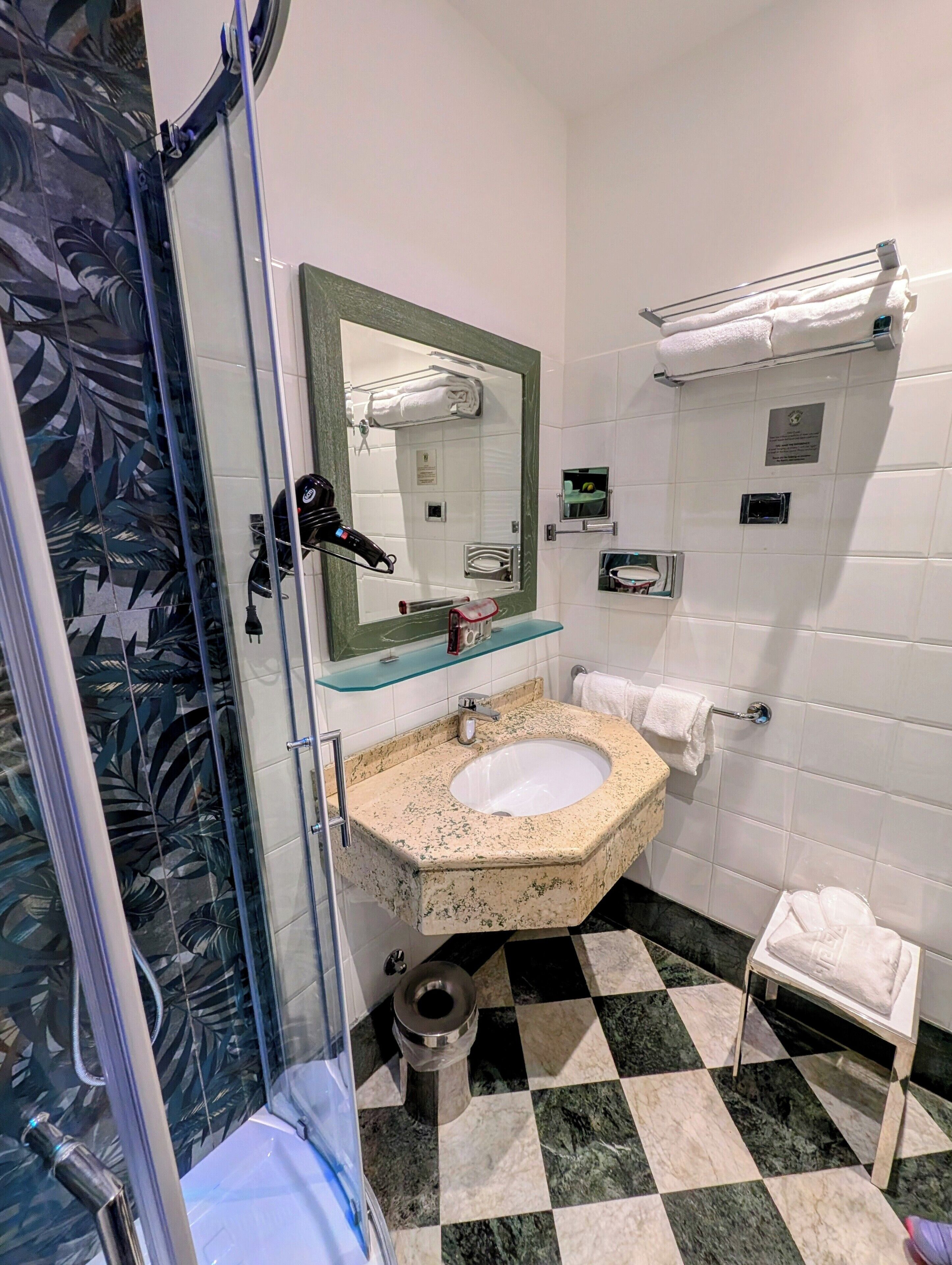 A bathroom with a large mirror, a sink, a toilet, and a shower area.