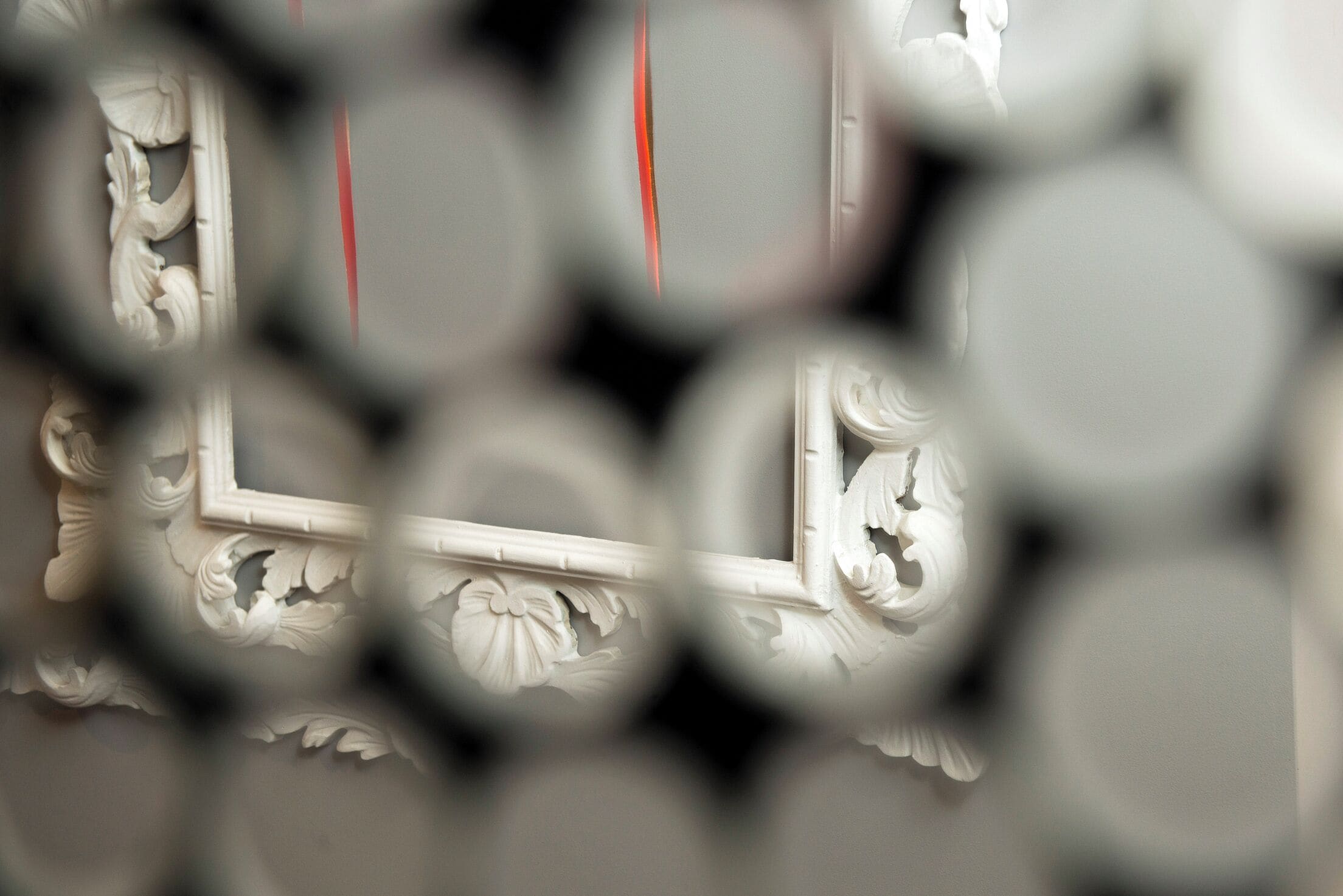 A close-up of a white ornate wall with a rectangular recess, possibly a niche or alcove.