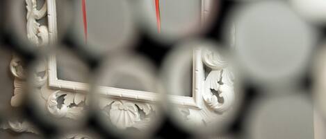 A close-up of a white ornate wall with a rectangular recess, possibly a niche or alcove.
