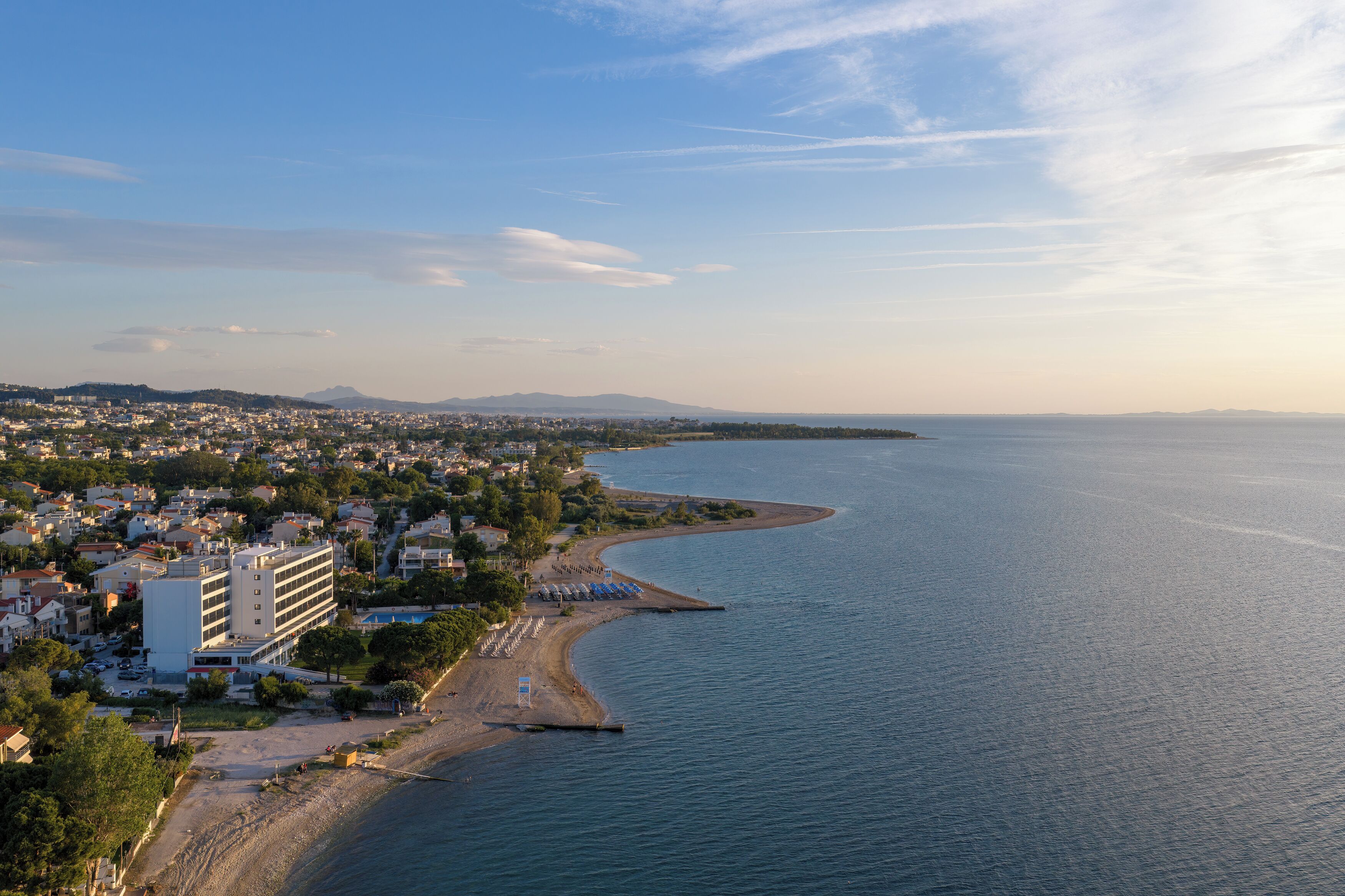 En kystby med strand, bygninger og en klar himmel.