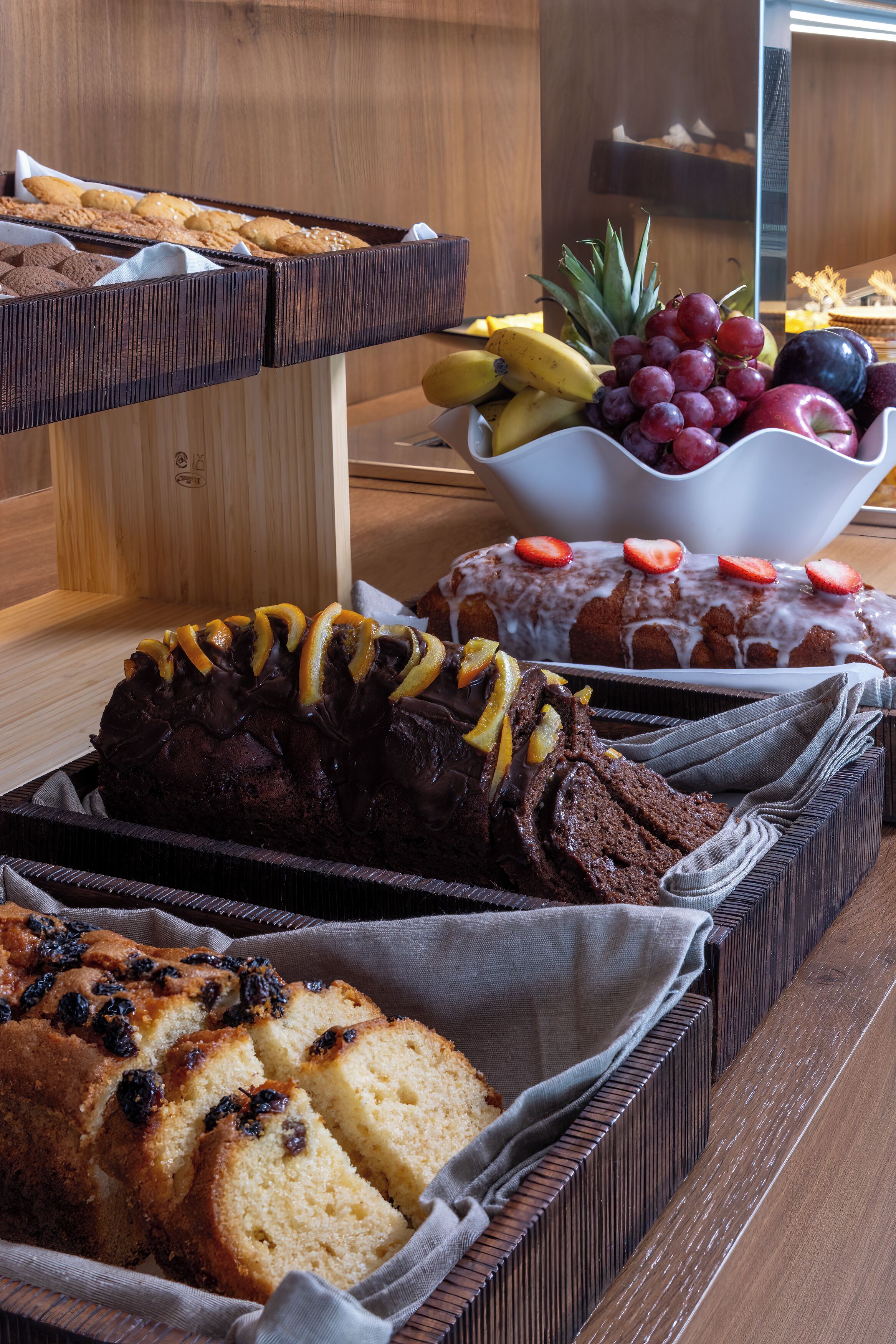 A variety of baked goods including a chocolate cake, a loaf of bread, and cookies.
