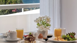 A breakfast table with a view of a bridge and mountains. - Airotel Achaia Beach (Patras)