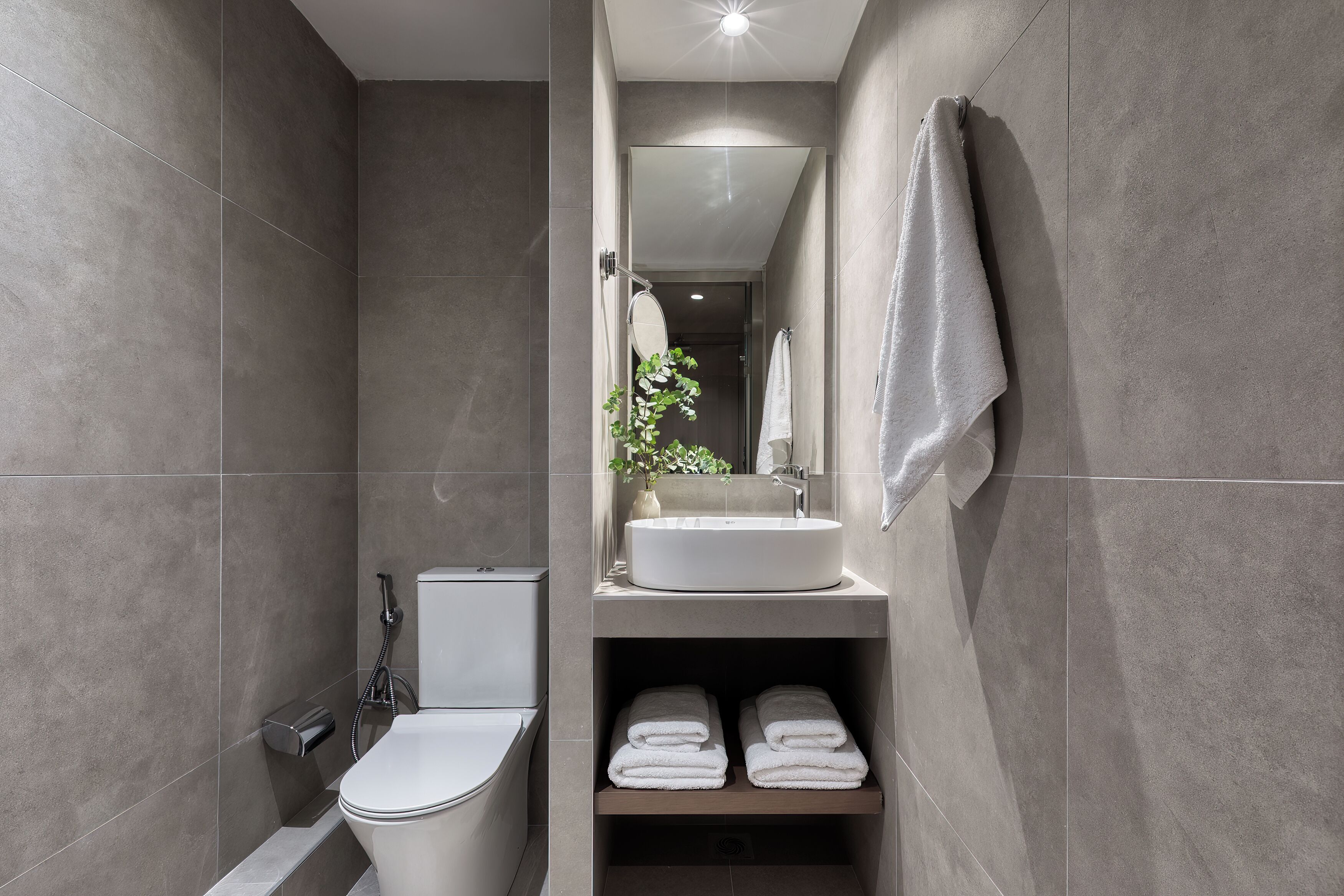 Un baño moderno con inodoro, lavabo y toallero.