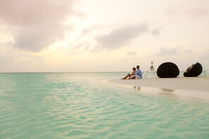 On the beach, white sand, sun loungers, beach umbrellas